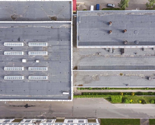 shingles roof of the industrial building with skylights. aerial top view._
