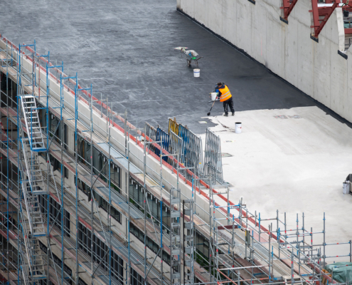 Workers painting commercial roof
