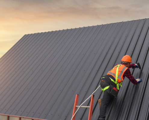 Roofer working on sloped commercial roof